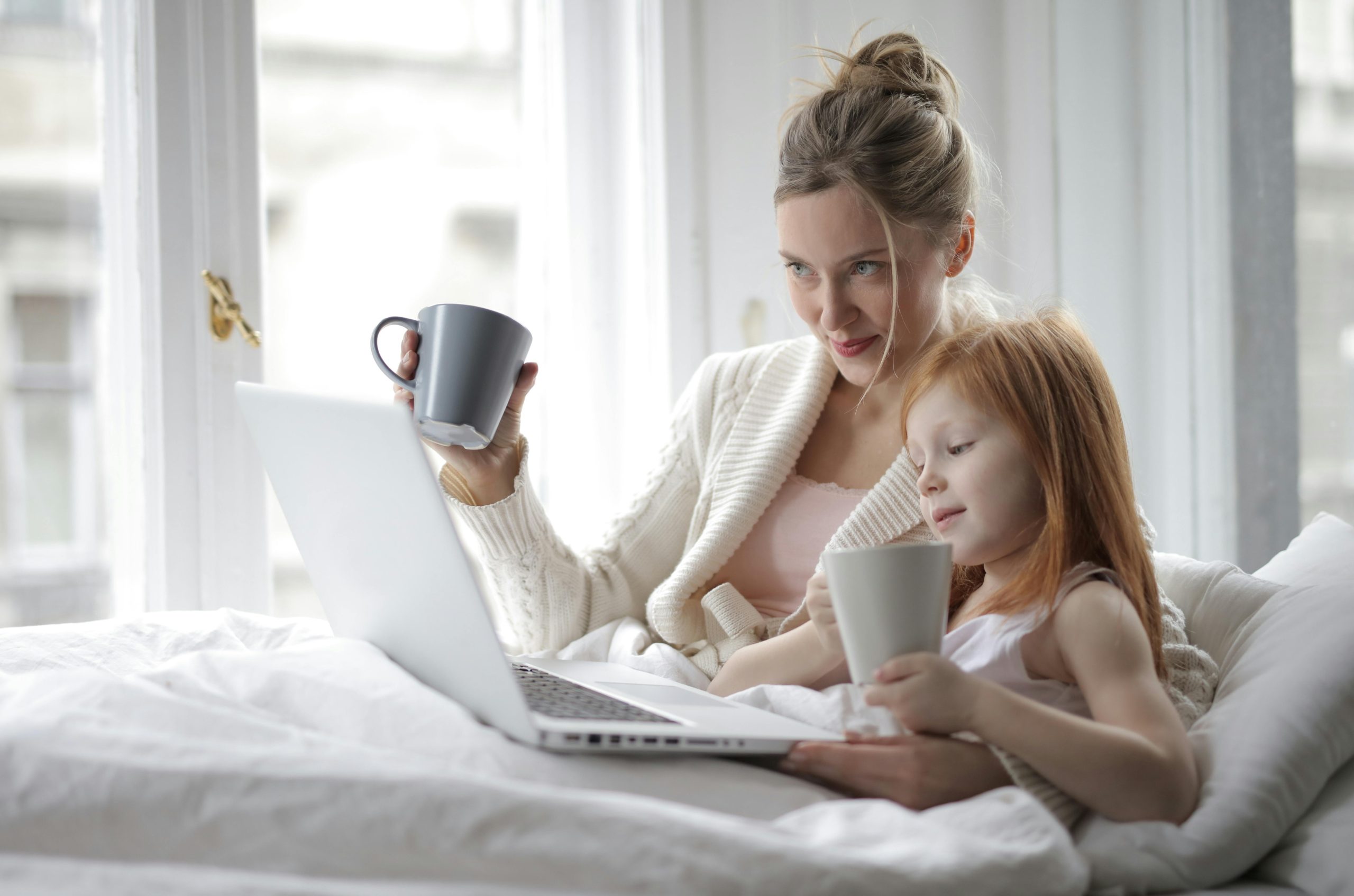 Mother and daughter smiling and looking at laptop