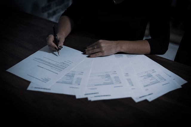 A lady signing a contract to sell land to developers