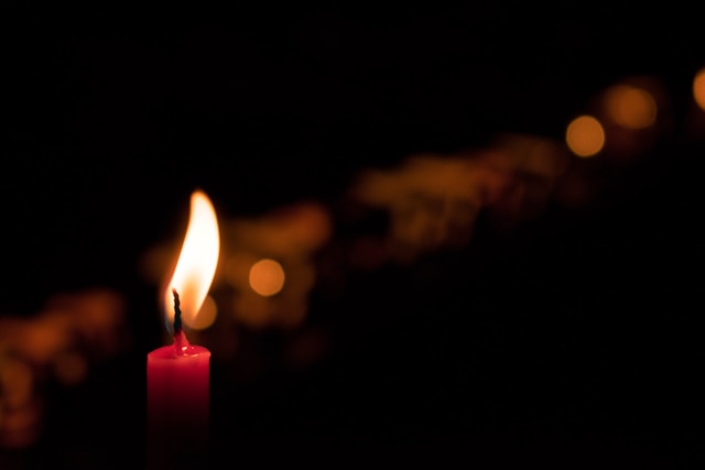 A candle against a dark background